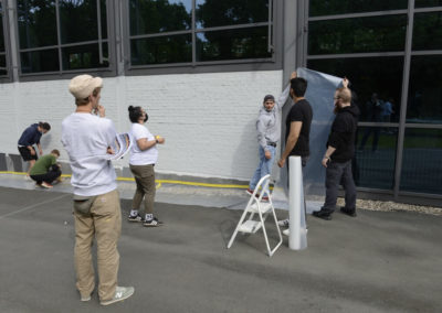 Schüler kleben eine Wand ab