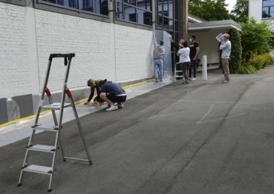 Schüler kleben eine Wand ab