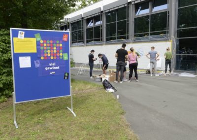 Schüler besprühen eine Wand mit Graffiti