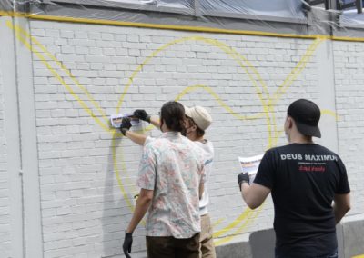 Schüler besprühen eine Wand mit Graffiti