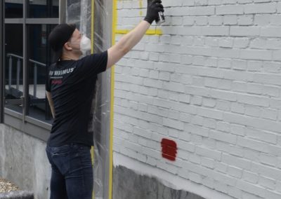 Schüler besprüht eine Wand mit Graffiti