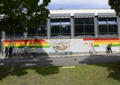 Schüler besprühen eine Wand mit Graffiti