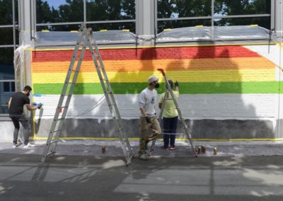 Schüler besprühen eine Wand mit Graffiti