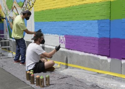 Schüler besprühen eine Wand mit Graffiti